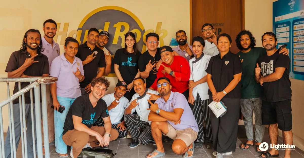 A diverse group photo of resort kitchen stewards, chefs, and service staff holding training certificates with Lightblue sustainability consultants