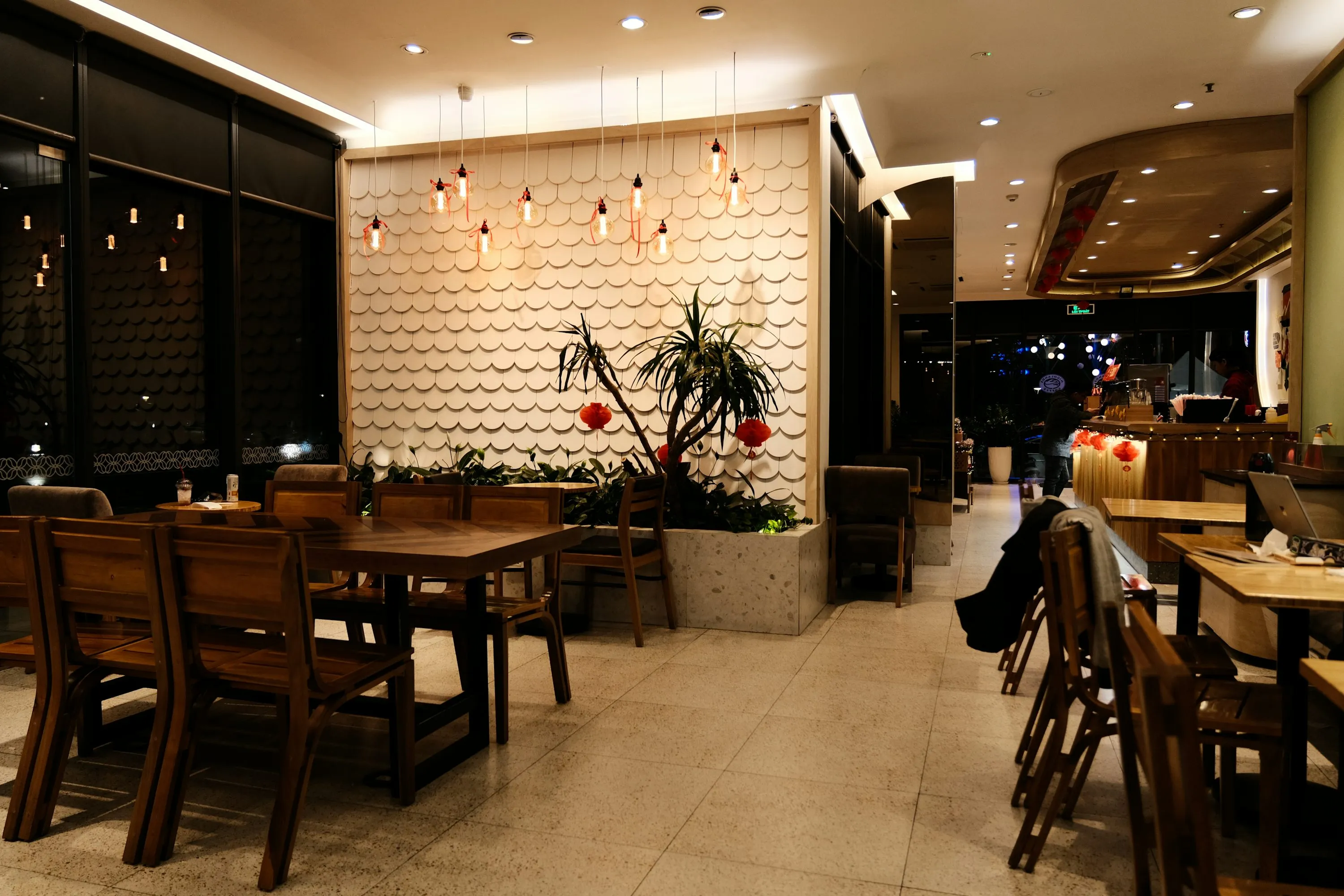 a restaurant with tables, chairs, and plants