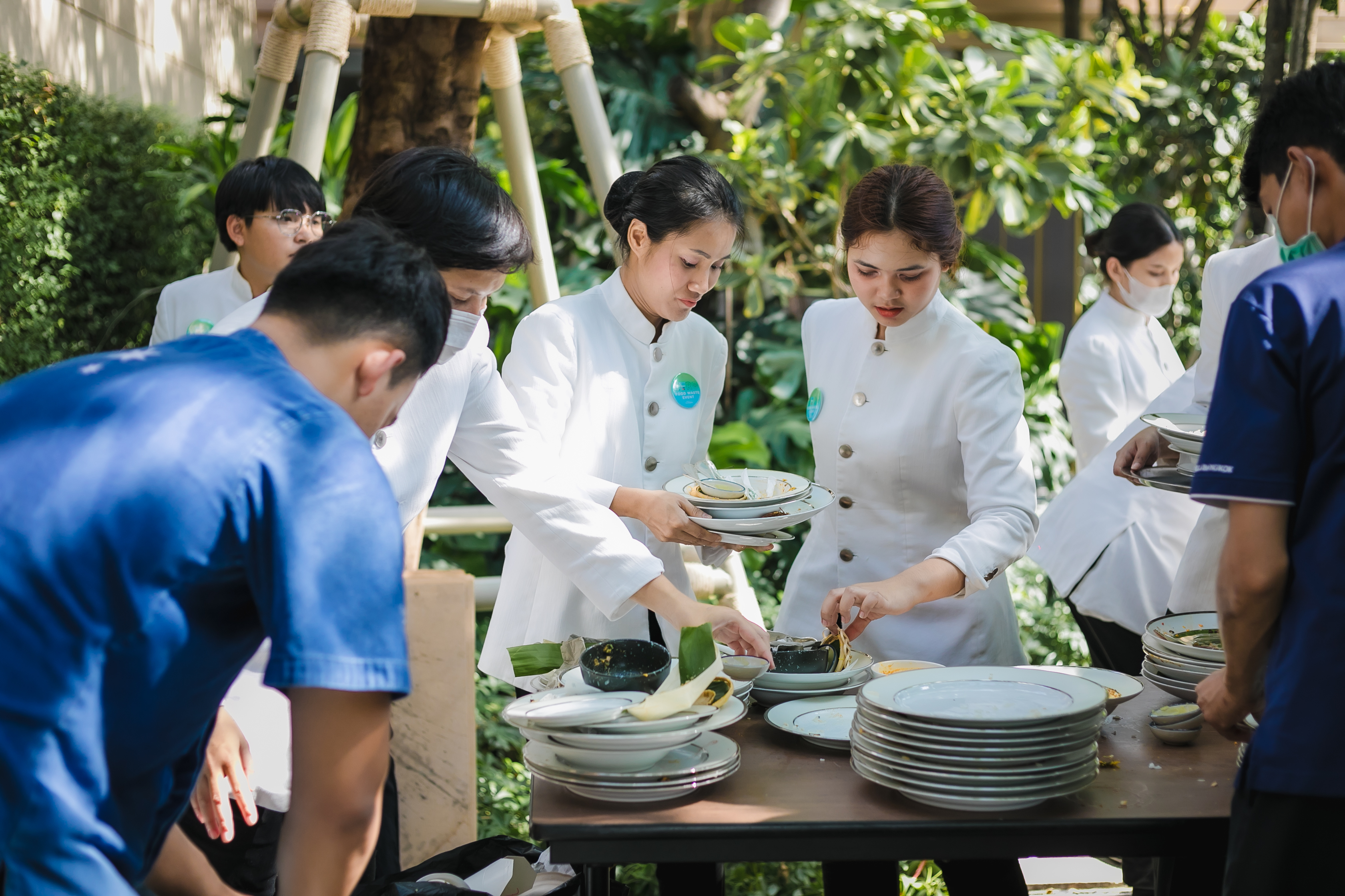 Event service staff at Capella Bangkok actively segregating organic waste into color-coded bins, following the waste flow design and signage provided by Lightblue to ensure zero food waste to landfill.