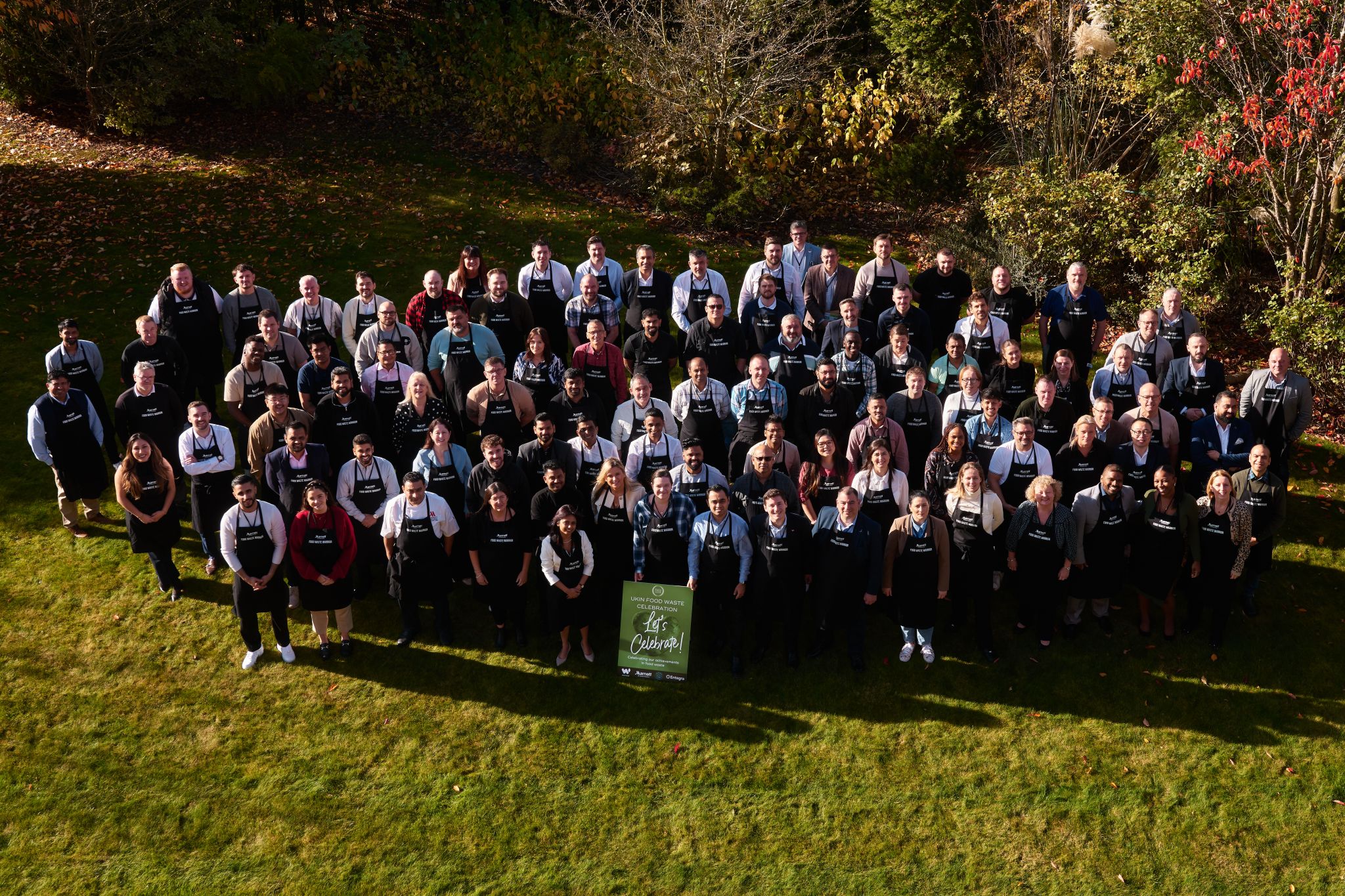 Marriott International hotel staff from the UK and Nordics region holding their "The PLEDGE on Food Waste" certification plaques during a celebratory event.