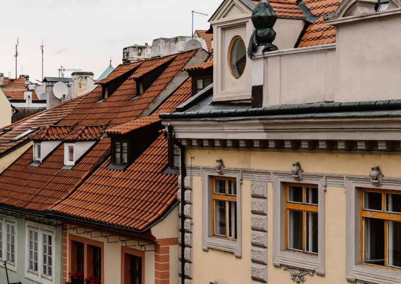 Historische Altstadthäuser mit roten Ziegeldächern und verzierten Fassaden.