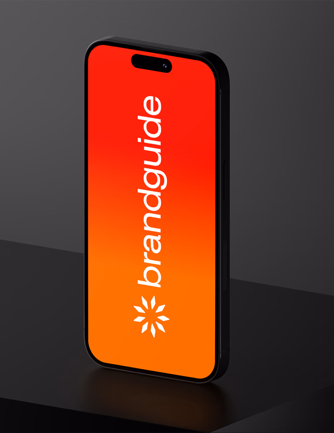 Black smartphone standing vertically on a dark surface with a red-to-orange gradient screen displaying the white text 'brandguide' and a white geometric logo below it.