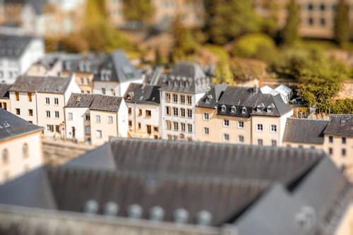 Mehrere historische Wohnhäuser in geschlossener Bauweise mit unterschiedlichen Dachformen und hellen Fassaden, aufgenommen aus erhöhter Perspektive