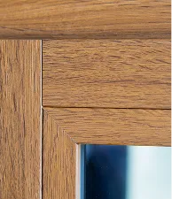 Coin d'un cadre en bois avec verre réfléchissant bleu.