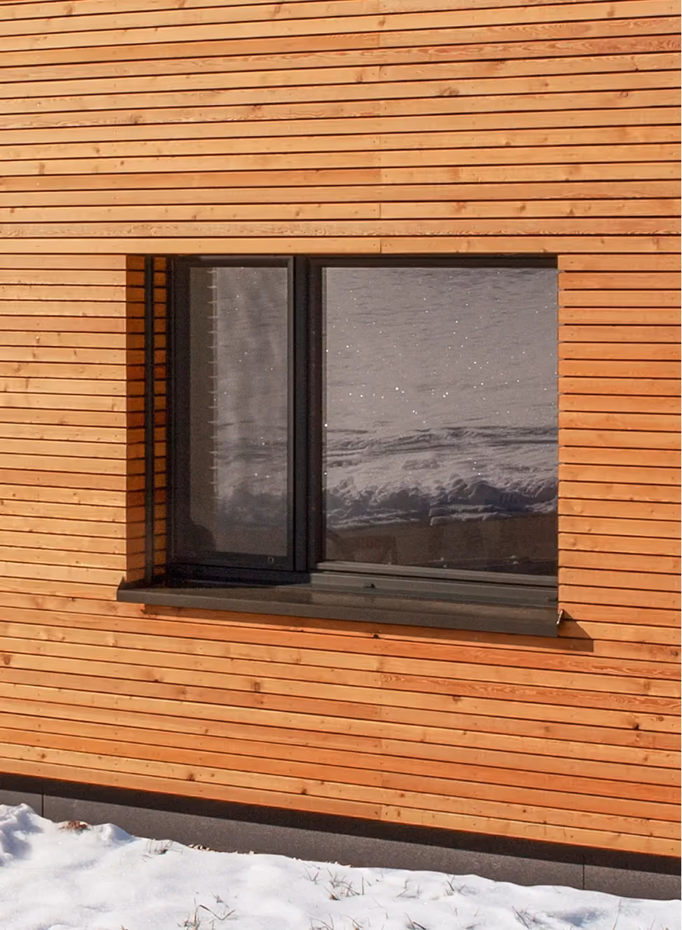 Fenêtre PVC Domofen posée sur une façade en bois.