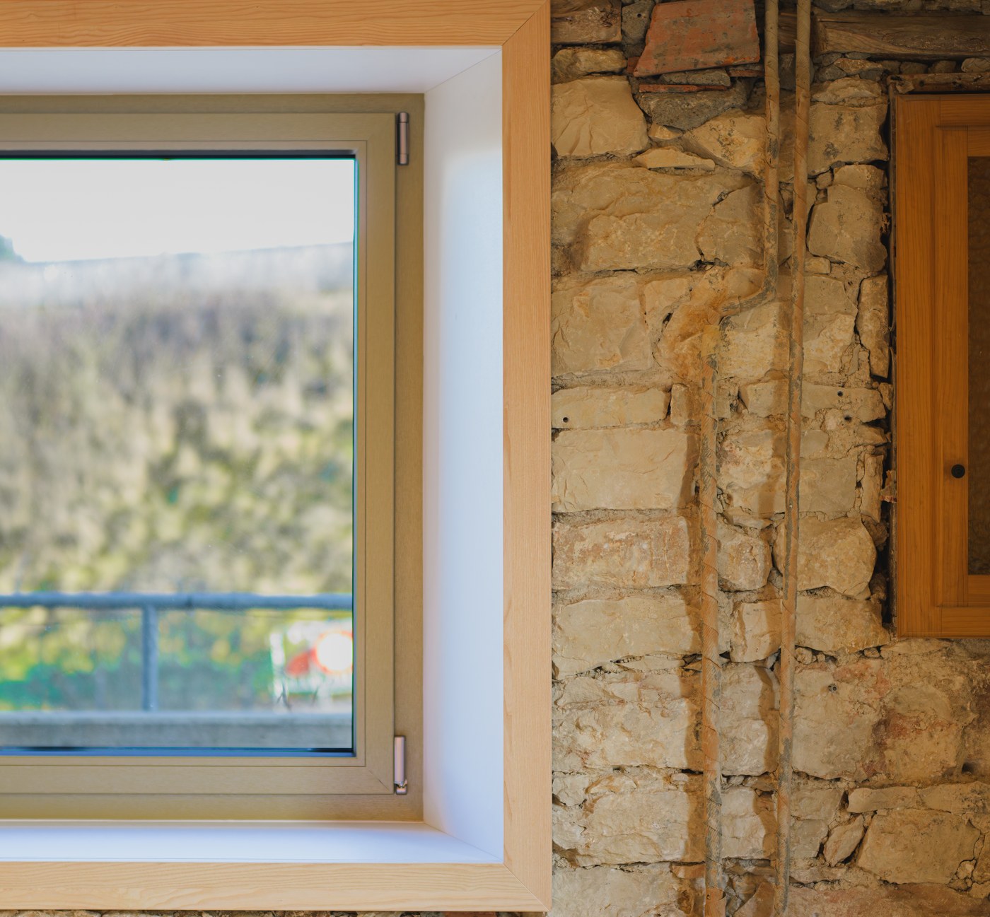 Fenêtre moderne à double vitrage posée dans un mur en pierre rustique.