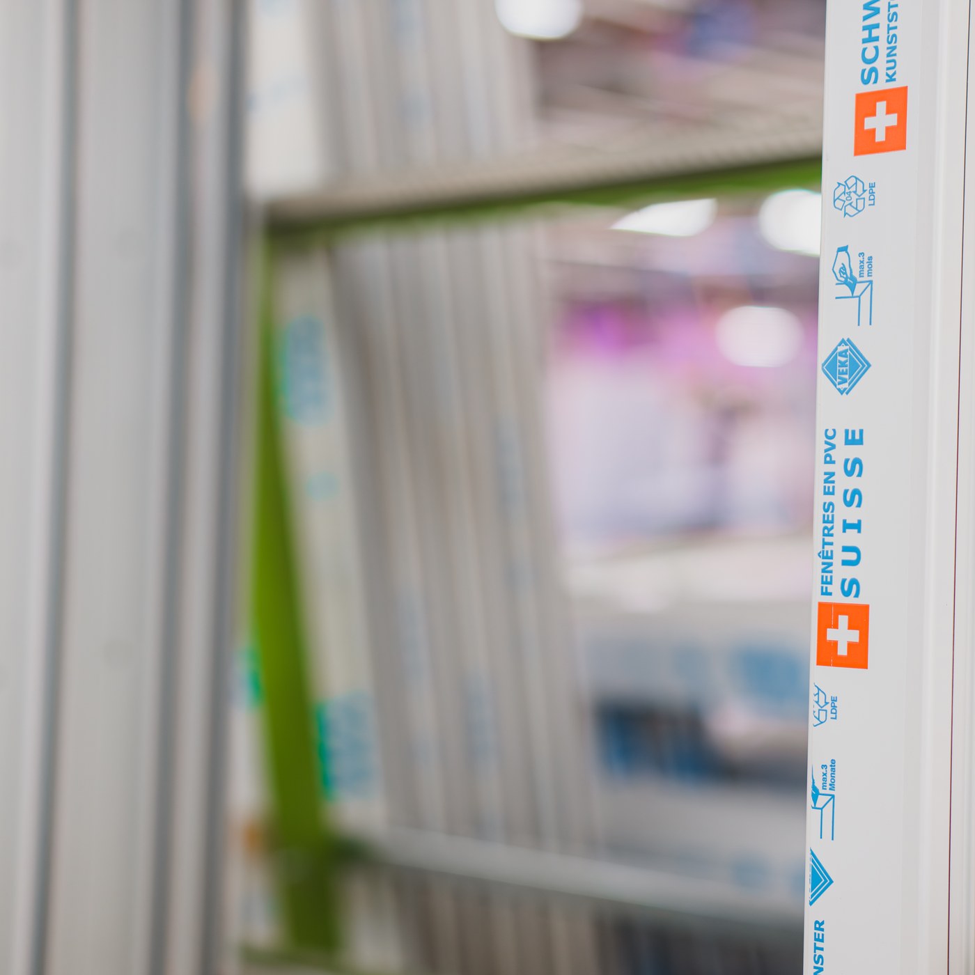 Profil de fenêtre en PVC blanc Domofen avec inscriptions bleues et symbole suisse orange.