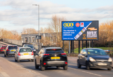 Cars driving on a multi-lane road next to a large billboard advertising CT1 sealant and adhesive.