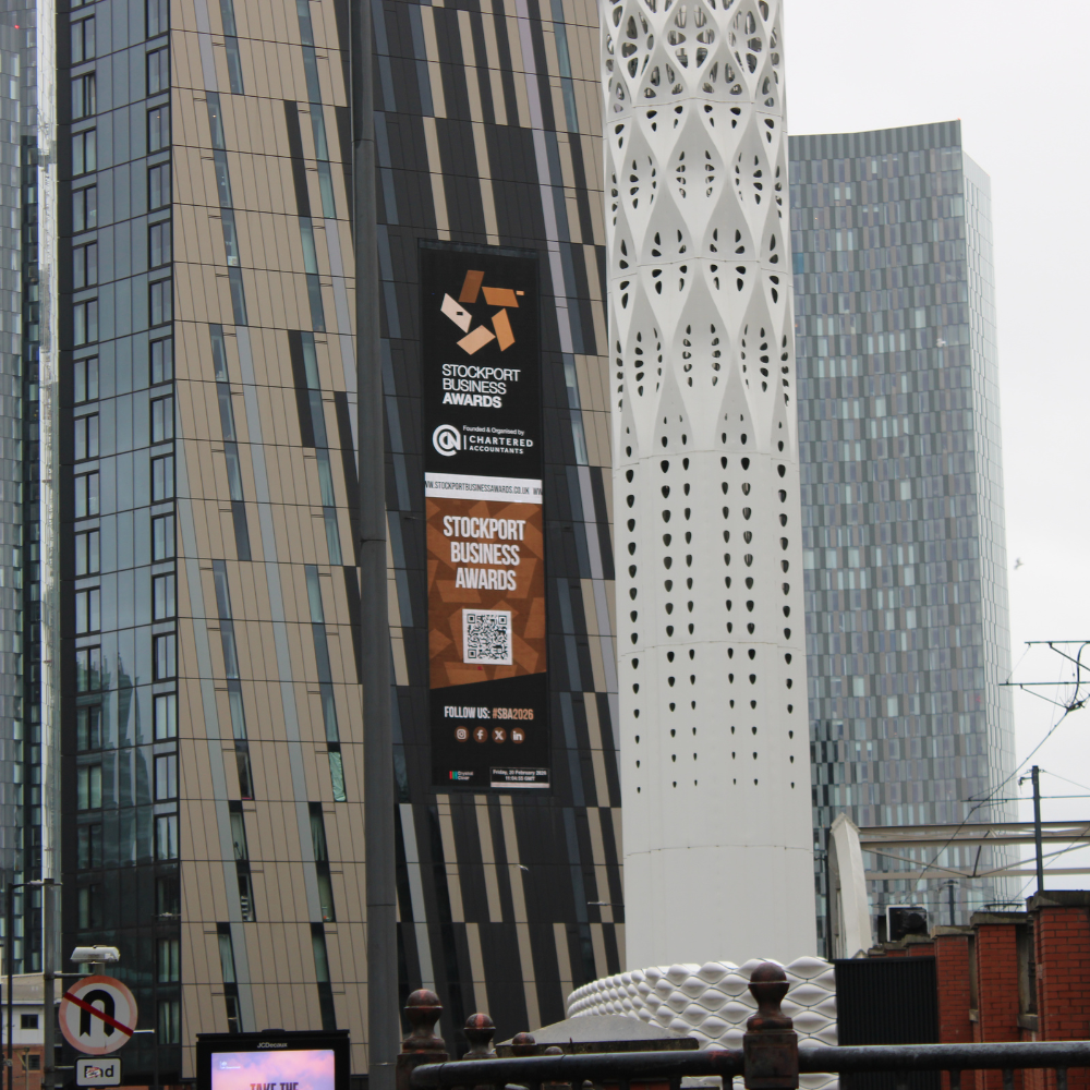 Stockport Business Awards banner on a modern, tall building with patterned windows and architecture.