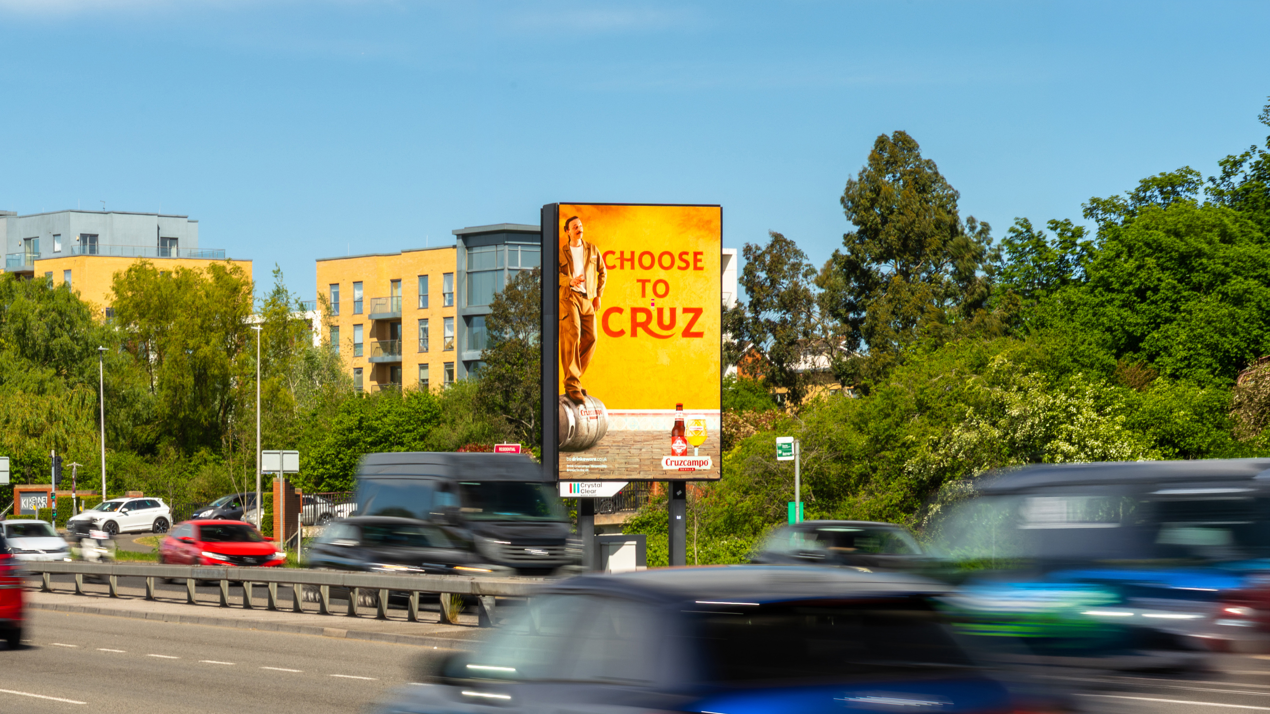 Digital billboard on highway ramp with advertisement for Tide small business accounts, cars and trucks moving on highway in background.