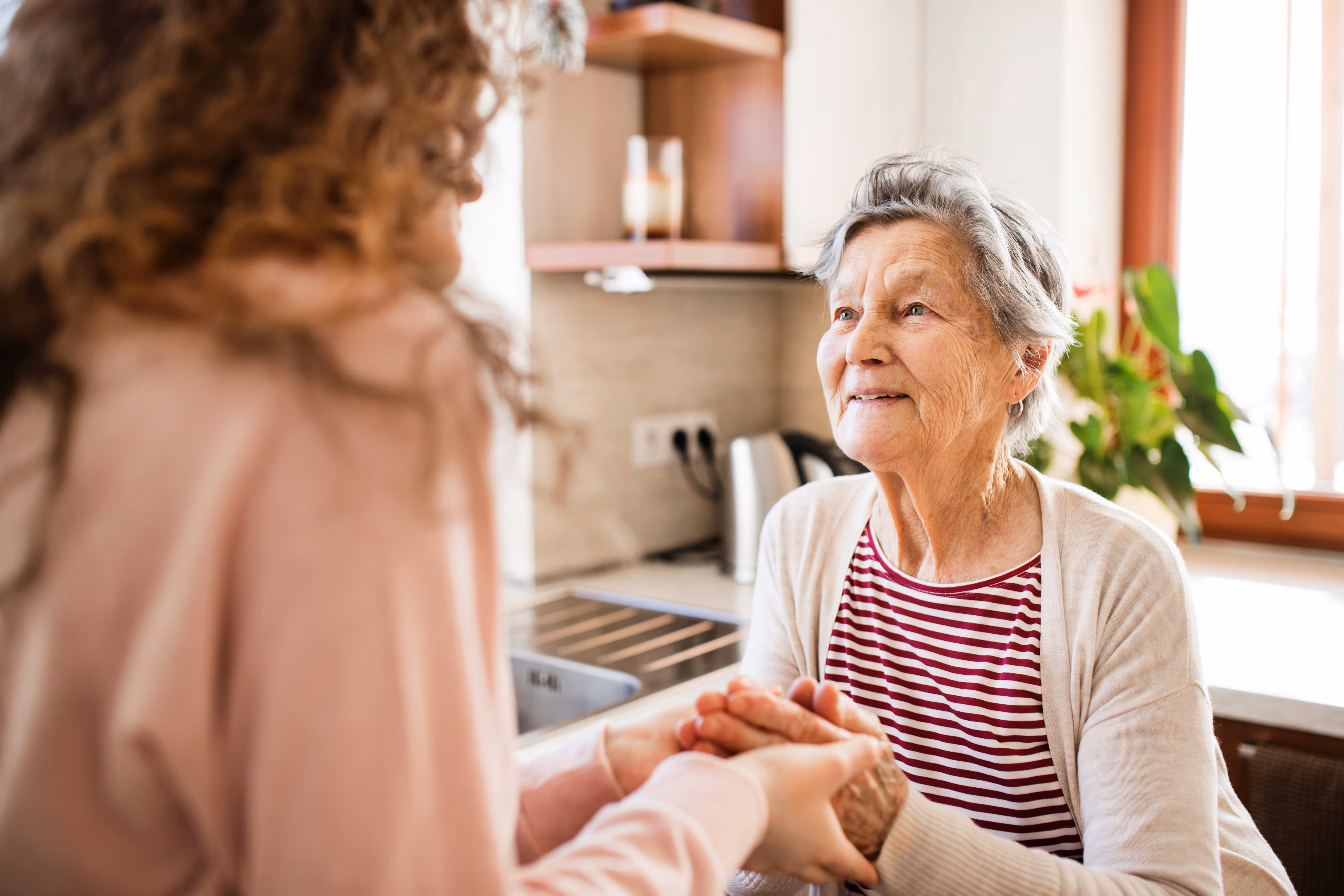 Dame âgée partageant un moment de complicité avec une aide à domicile de Provence Aide Services.