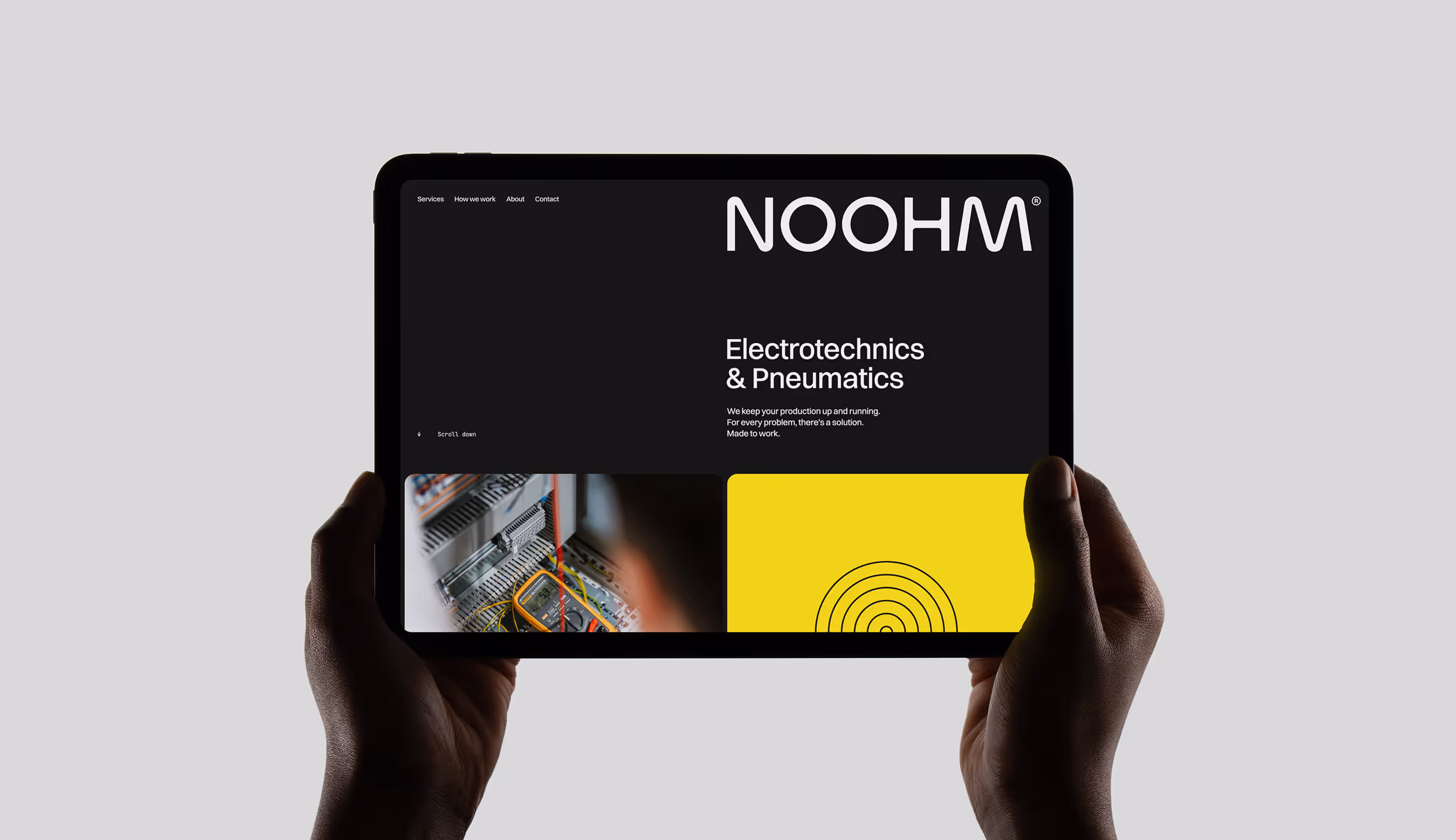 Tablet in handen die de Noohm-website toont met het zwarte logo, gele accenten en de tekst “Electrotechnics & Pneumatics – Made to work.”