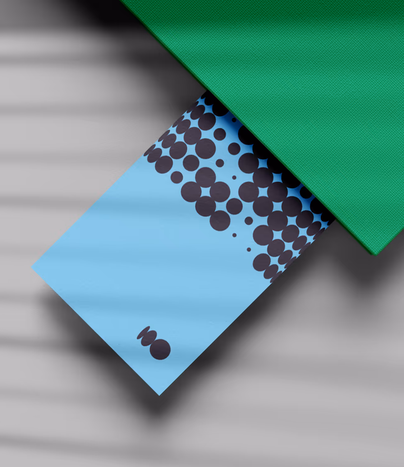 Lichtblauw kaartje met donkergrijze stippenpatronen en Ameleo-logo, deels zichtbaar onder een groene map.