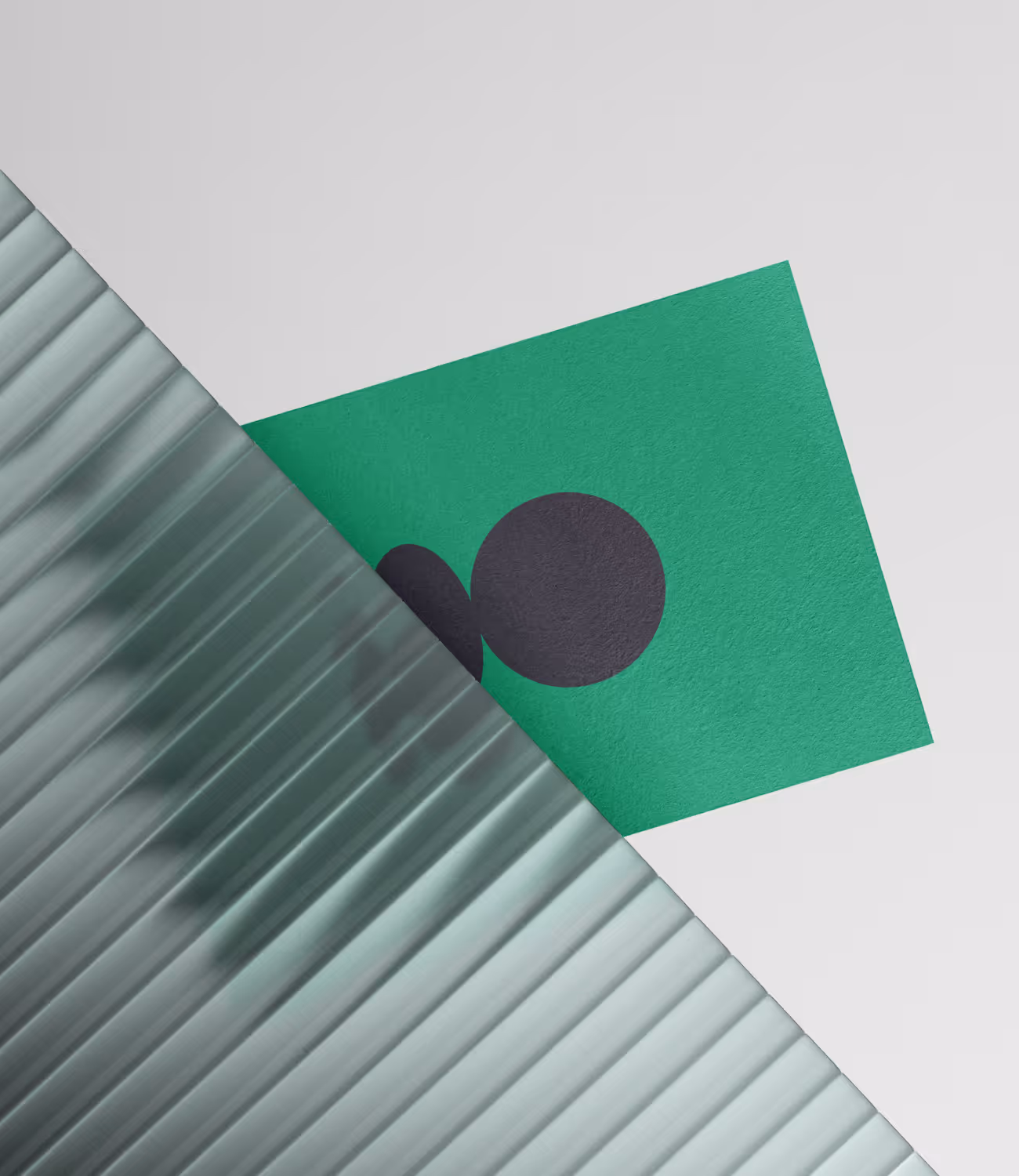 Groen visitekaartje met donker Ameleo-logo, half verscholen achter een doorschijnende ribbelplaat.