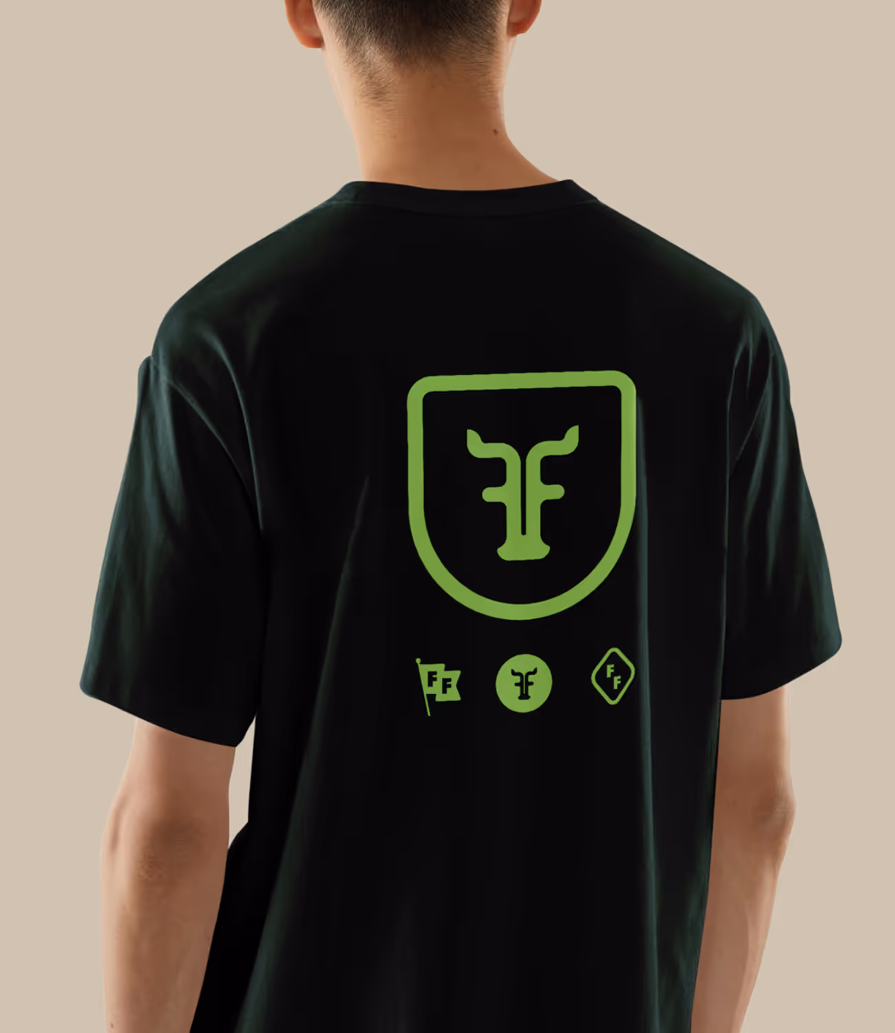 Donkergroen T-shirt met groot FF-logo en iconenset op de rug — stoer, herkenbaar en vrolijk in lijn met de merkstijl.