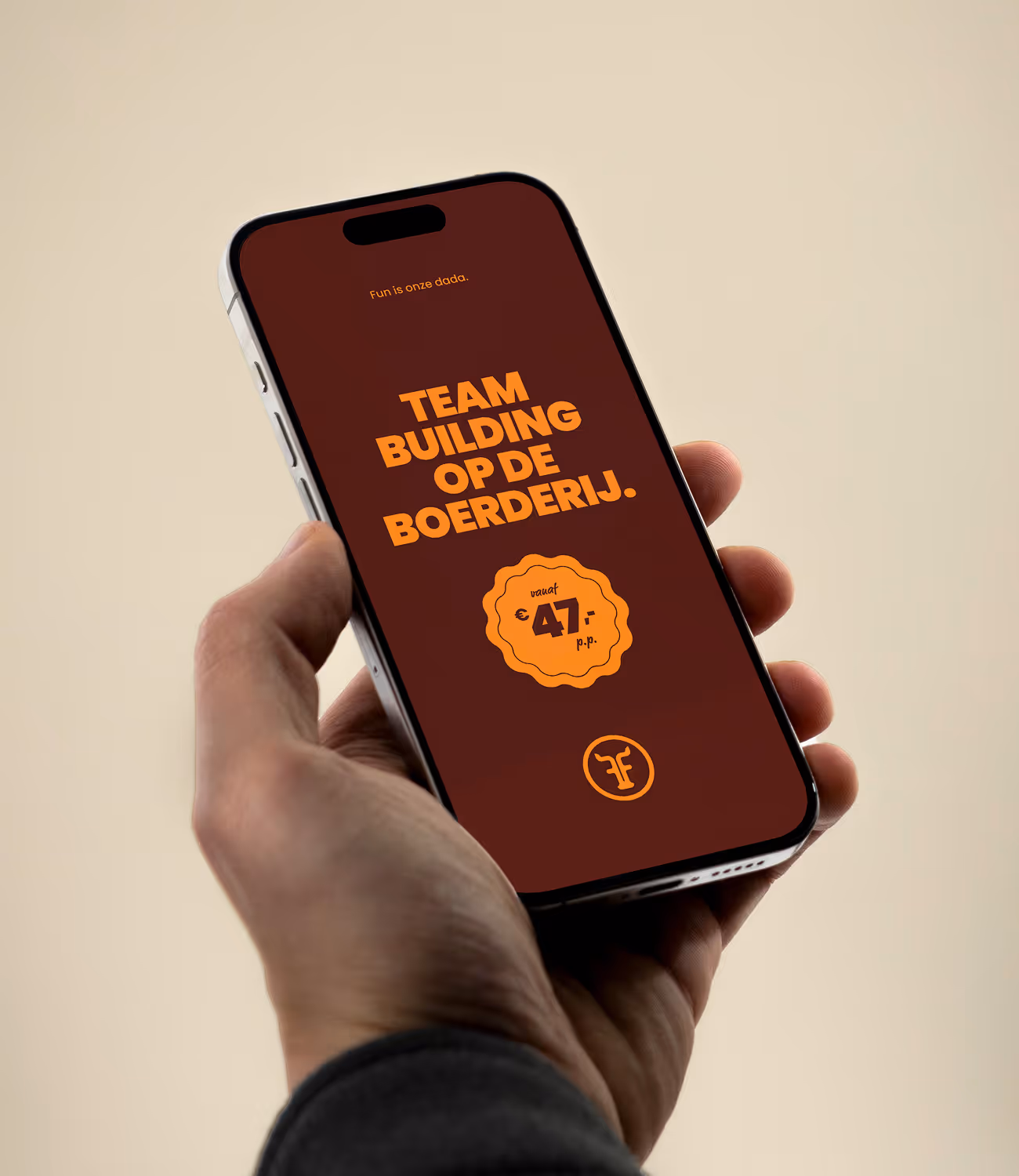 Smartphone met de boodschap “Teambuilding op de boerderij” in oranje typografie op een wijnrode achtergrond — frisse, speelse campagne.