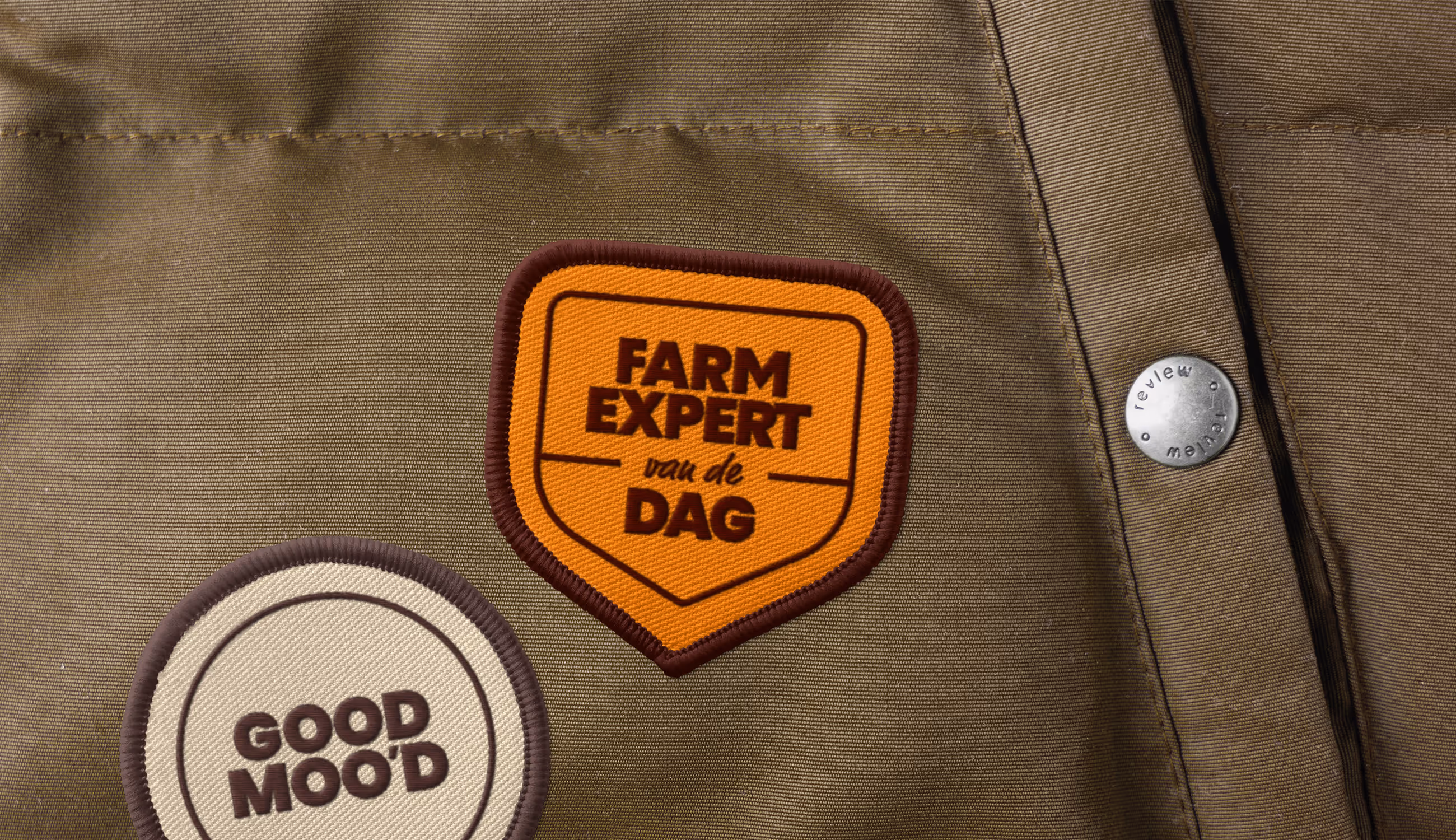 Close-up van textielpatches met opschriften “Farm Expert van de dag” en “Good Moo’d” — stoer, ambachtelijk en met een knipoog.