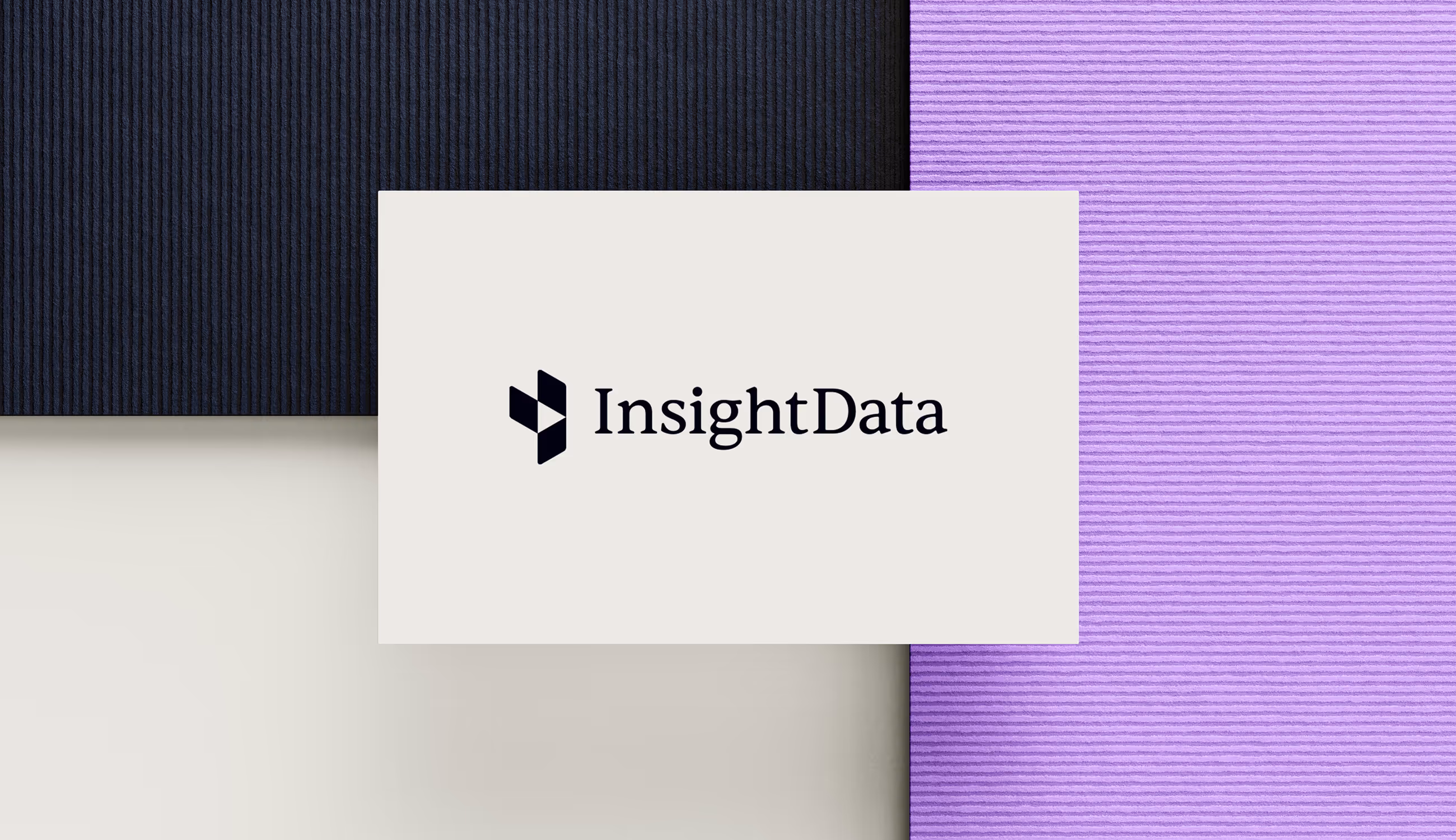 Het InsightData-logo op een rechthoekige kaart, geplaatst op een achtergrond van donkerblauw en lila papier met fijne ribbelstructuur.