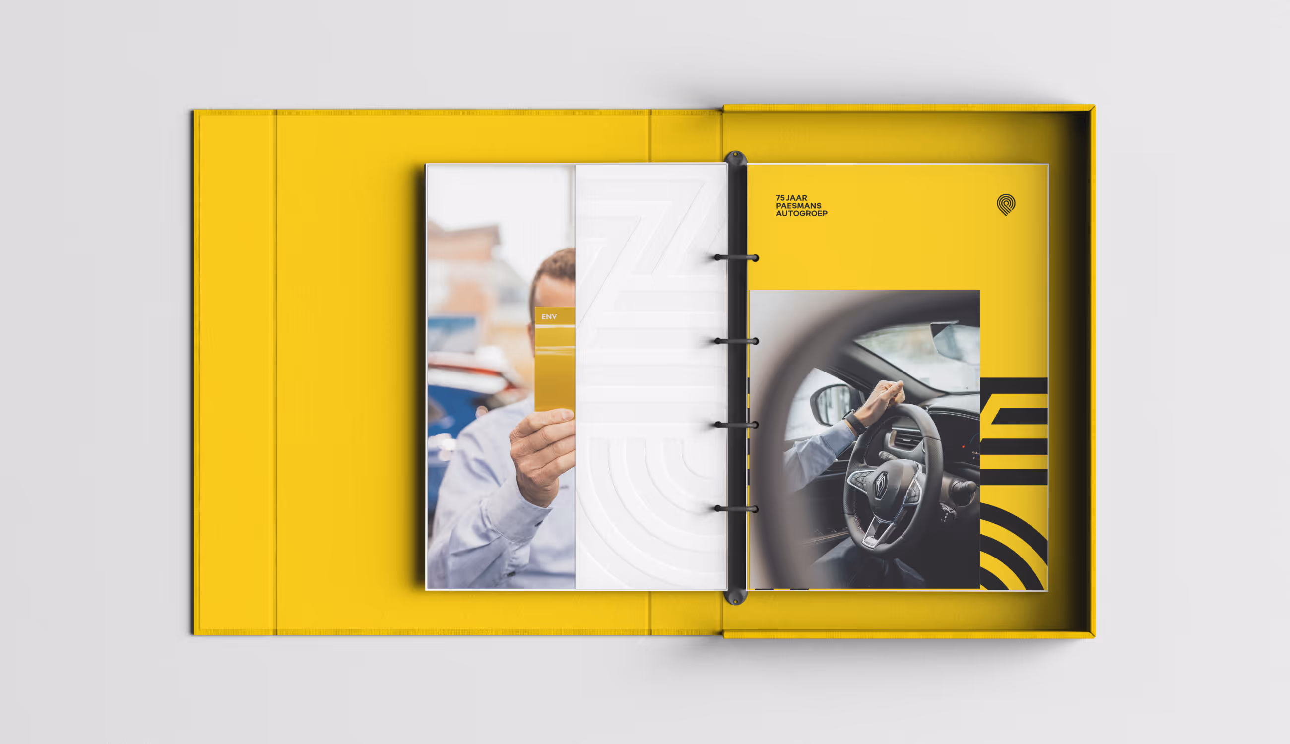 Gele ringmap met foto’s en pagina’s over het 75-jarig jubileum van Paesmans Autogroep, met zwart-geel design.