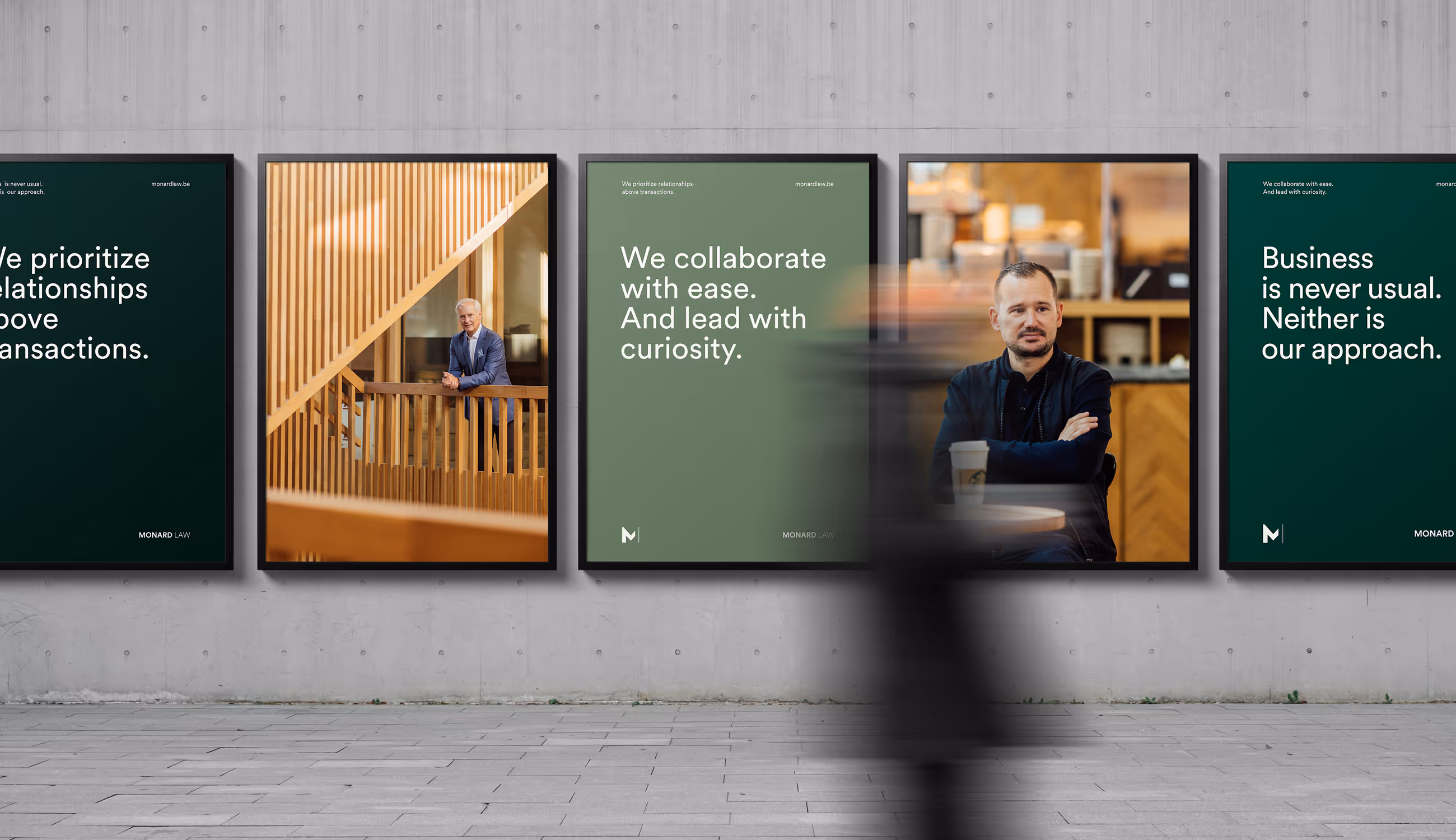 Posters met Monard Law-boodschappen en portretten tegen betonnen muur.