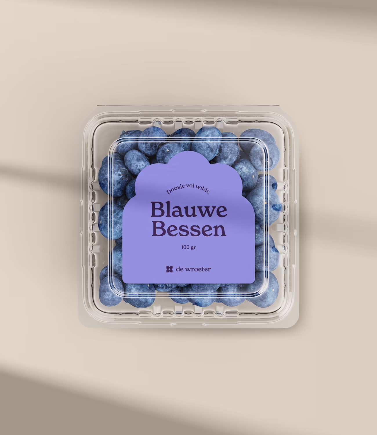 Verpakking van blauwe bessen met paars label en De Wroeter-logo, strak en ambachtelijk vormgegeven.