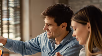 Smiling man and woman having a tea break together in an office setting.