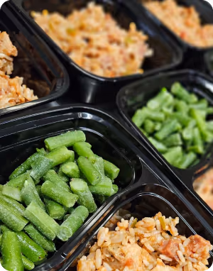 Black containers filled with chopped green beans and rice with vegetables.