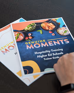 Cover of a hospitality training guide titled 'Genuine Moments' featuring images of food dishes.