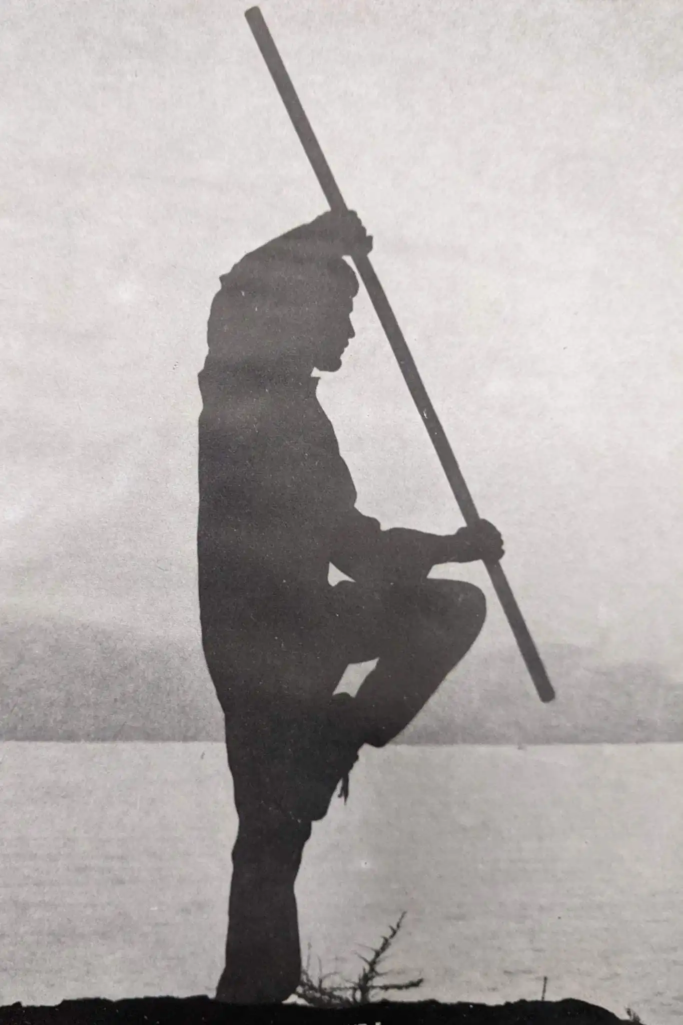 Σιλουέτα ασκούμενου Tai Nui Kung Fu σε υπαίθρια προπόνηση με μακρύ όπλο δίπλα στη θάλασσα