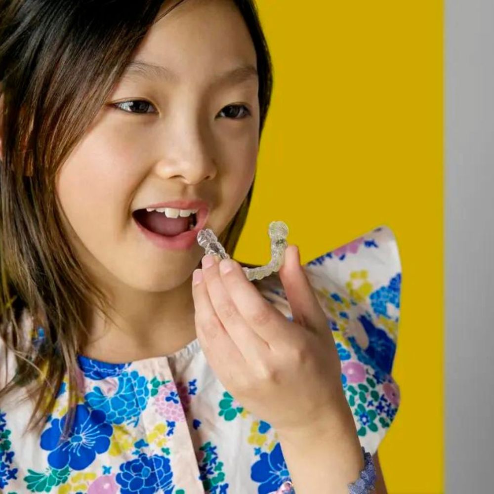 Young girl putting in Invisalign trays