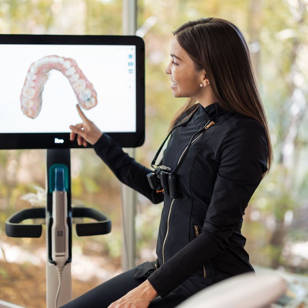 Woman pointing at a screen with teeth on it.