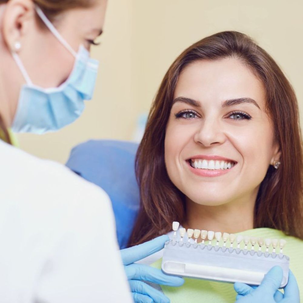 woman comparing natural teeth to implant
