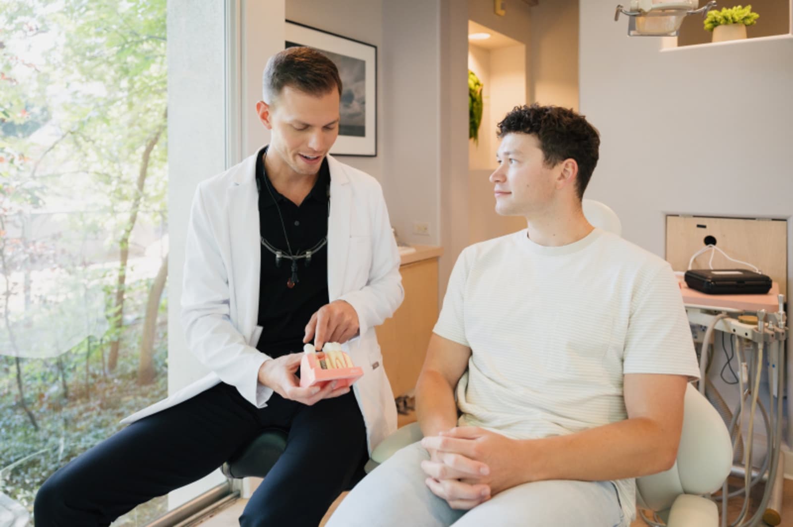 Dental professional consulting with patient about treatment options in bright clinical space