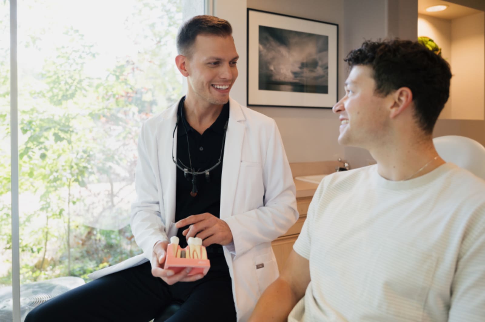Dentist discussing smile design plan with patient in treatment area