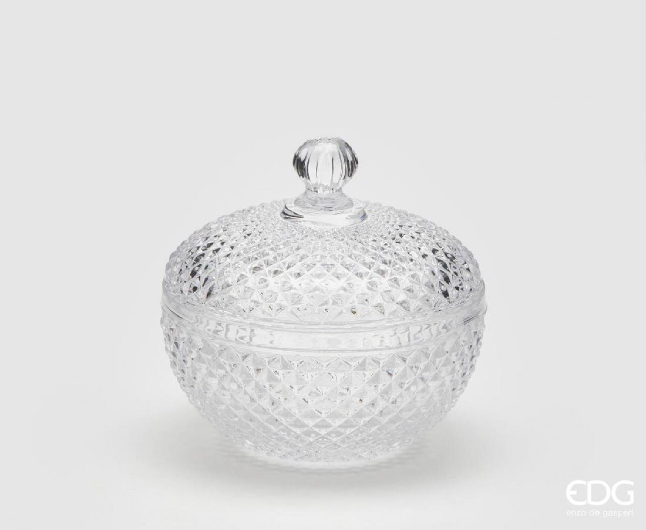 A decorative glass container designed with a classic cut pattern that reflects light and adds texture to any setting. The structured shape is complemented by a fitted lid with a rounded handle, making it both practical and visually balanced. Suitable for storing sweets, small treats, or decorative items, it works well as a functional piece on a table, shelf, or countertop. 