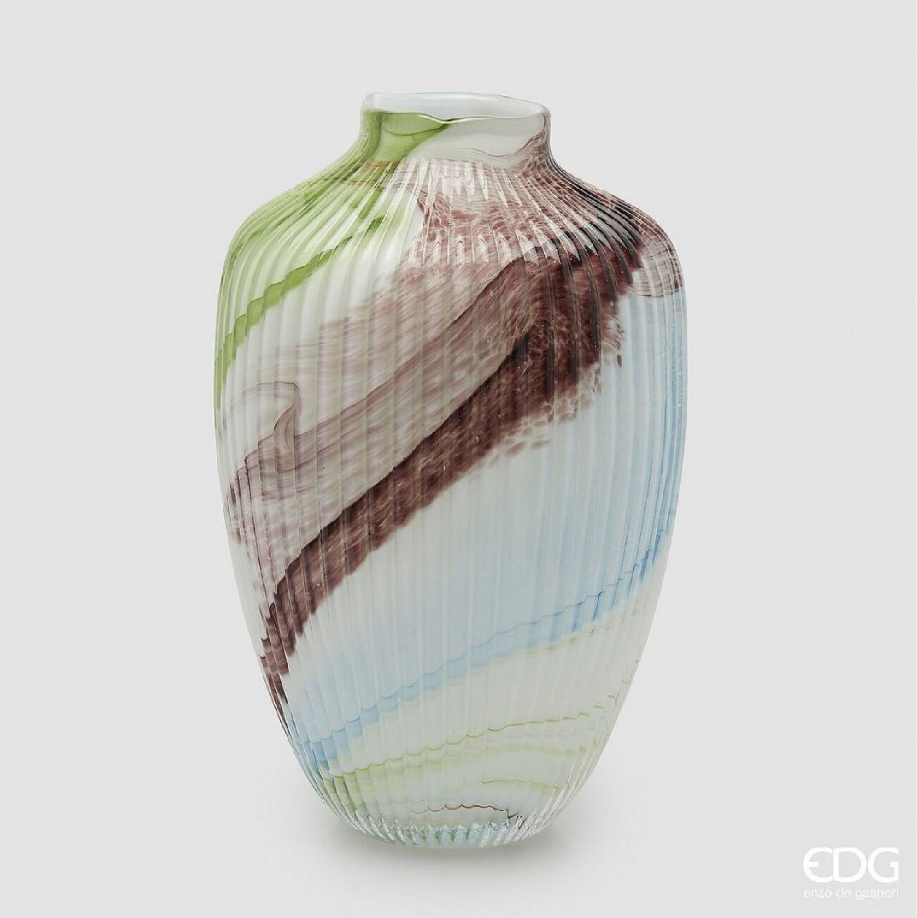 A sculptural glass vase featuring a blend of green, soft blue, and earthy tones arranged in flowing layers. The ribbed texture adds depth and structure, while the organic color transitions create a sense of movement. Designed as a statement piece, it works well with fresh or dried arrangements, or as a standalone decorative element in modern and natural interiors. Short description
