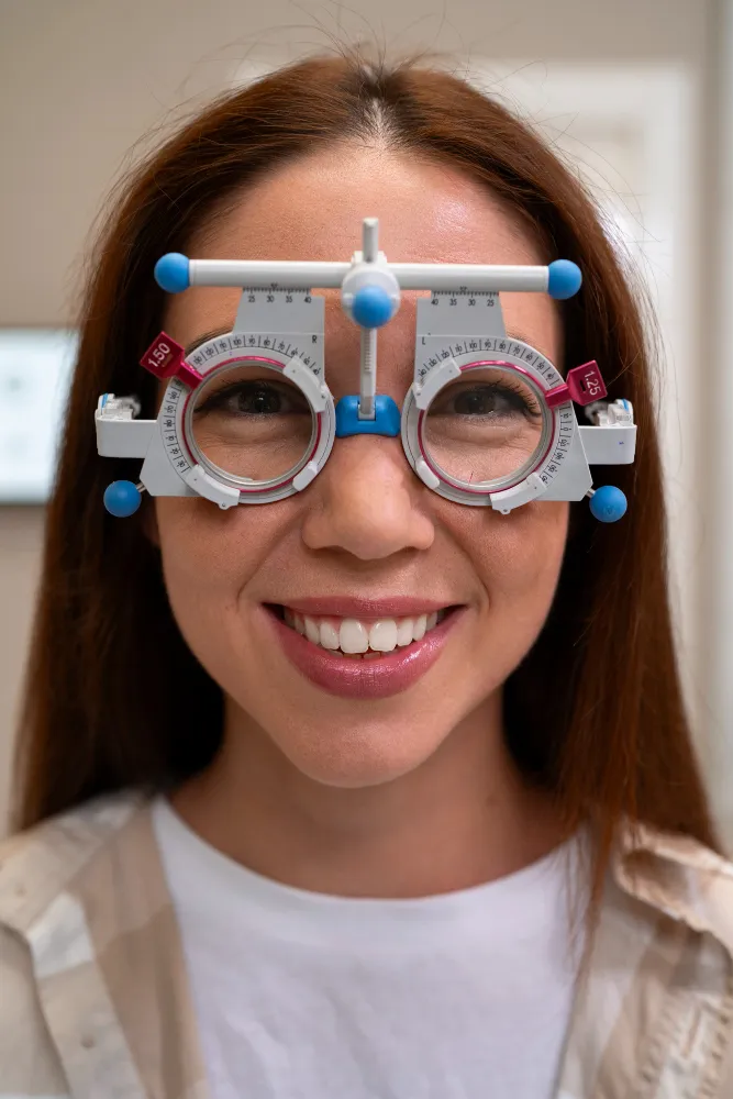 Woman wearing an optical phoropter refraction testing device during eye examination