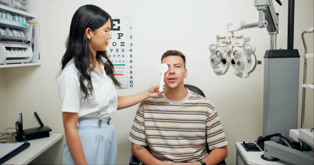 Optometrist examining patient's eyes using phoropter in clinical setting