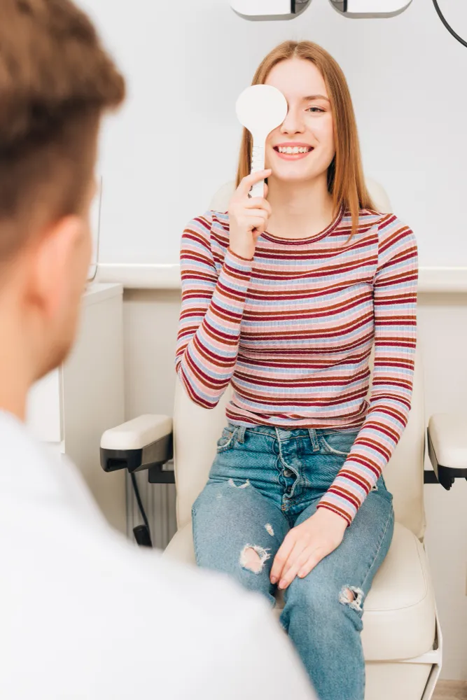 Young woman holding white speech bubble in conversation with another person, smiling.