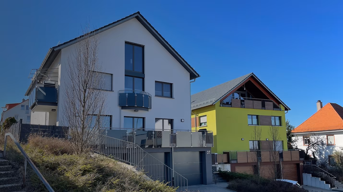 2 häuser im vordergrund mit garage