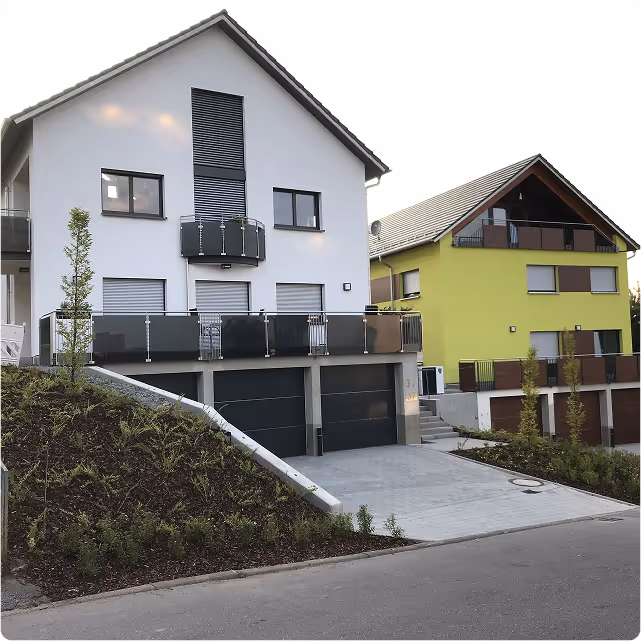 2 häuser im vordergrund mit garage