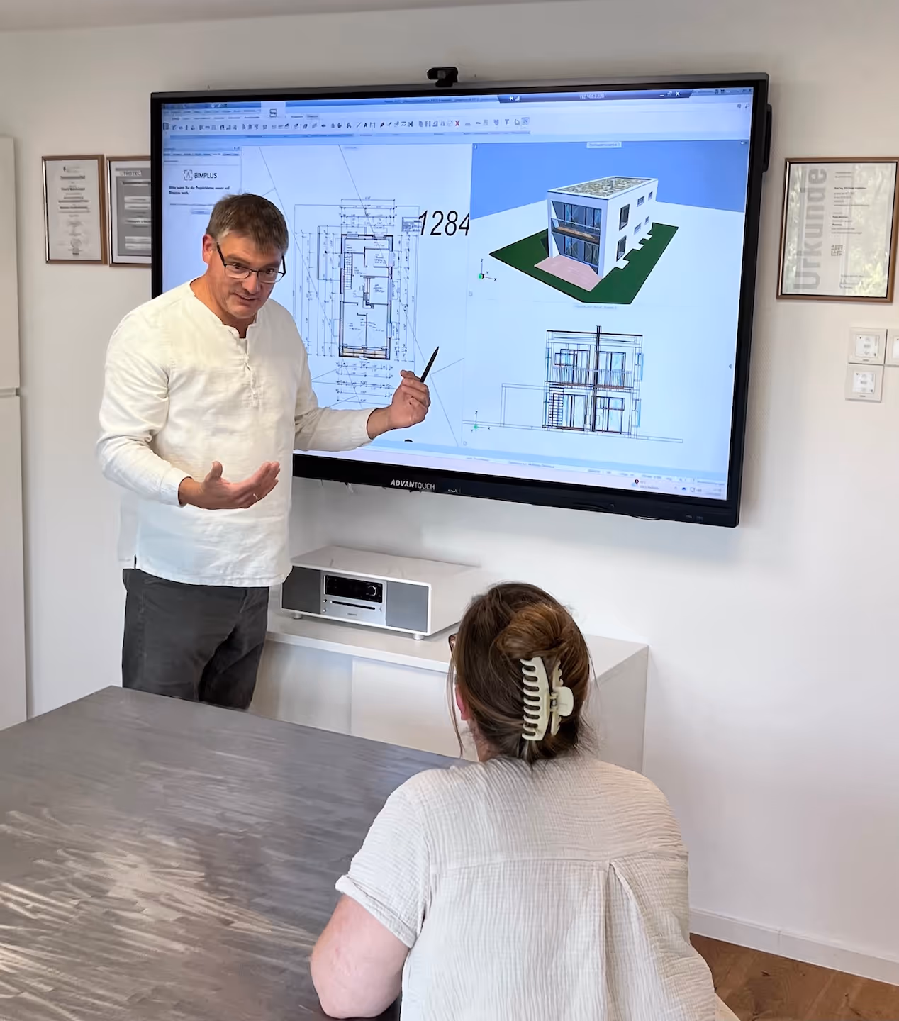 architekt mit kundin vor einem smartboard