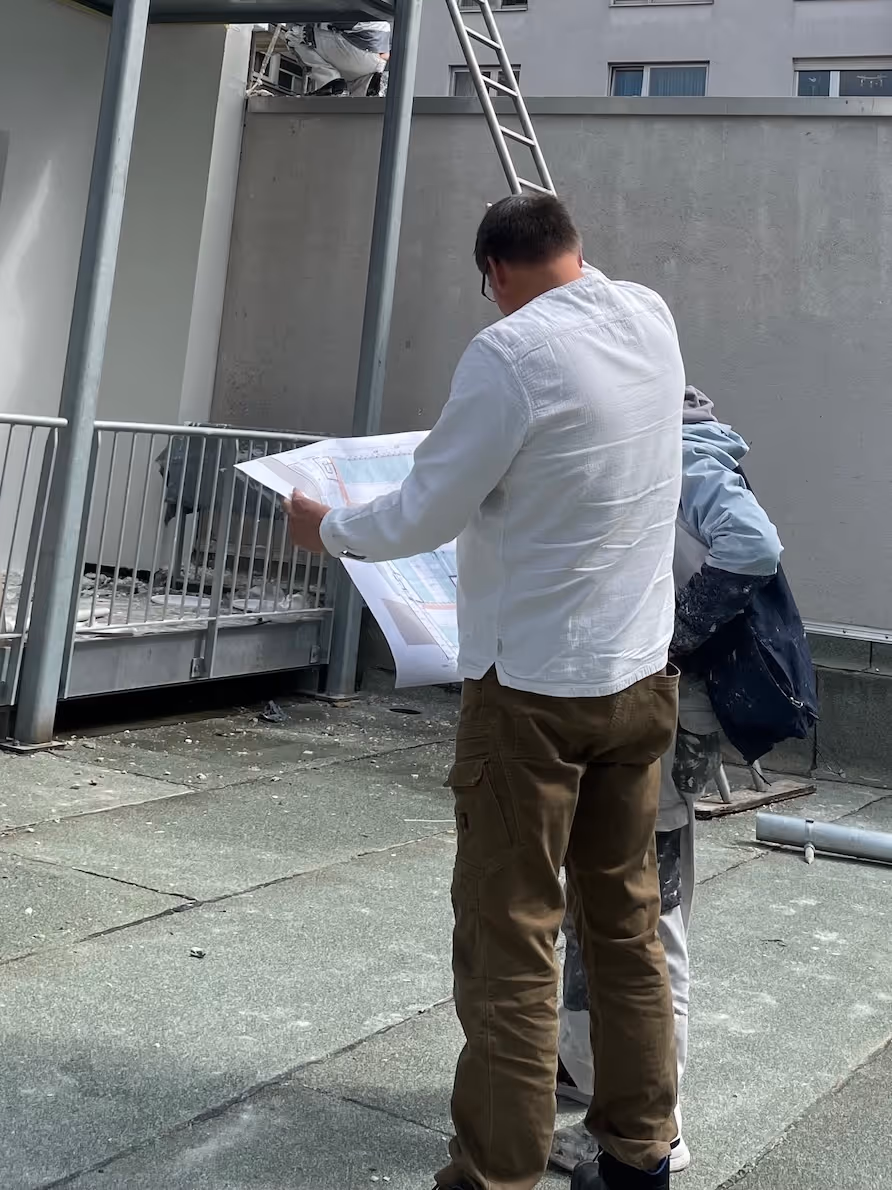 architekt mit plan in der hand vor bauprojekt