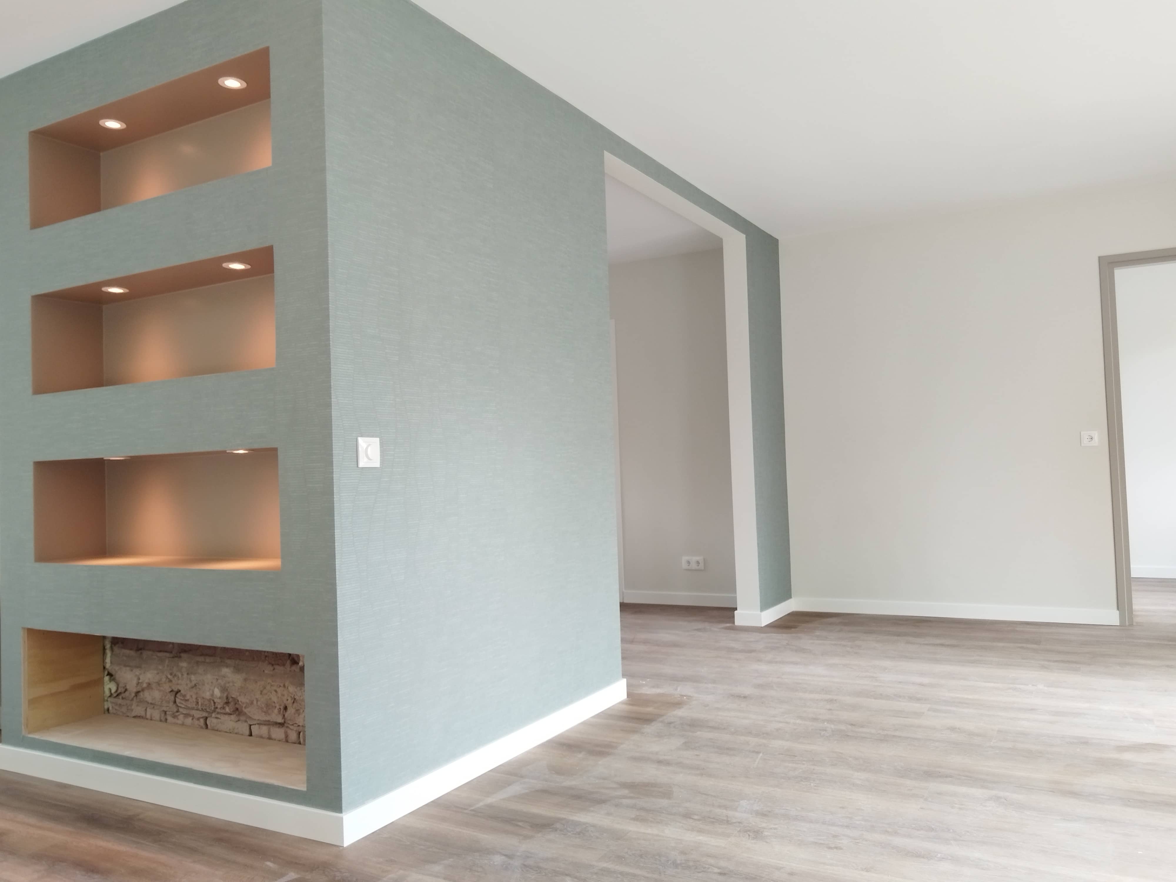 Wanden behangen in moderne woning met gestructureerd vliesbehang, inclusief afwerking van inbouwnissen.