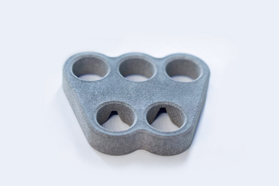 3D printed bracket with five circular bores.