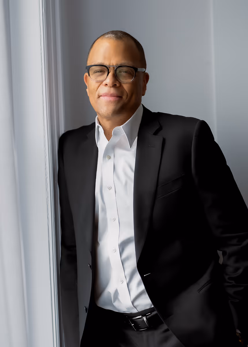 Philip in a suit smiling at the camera 