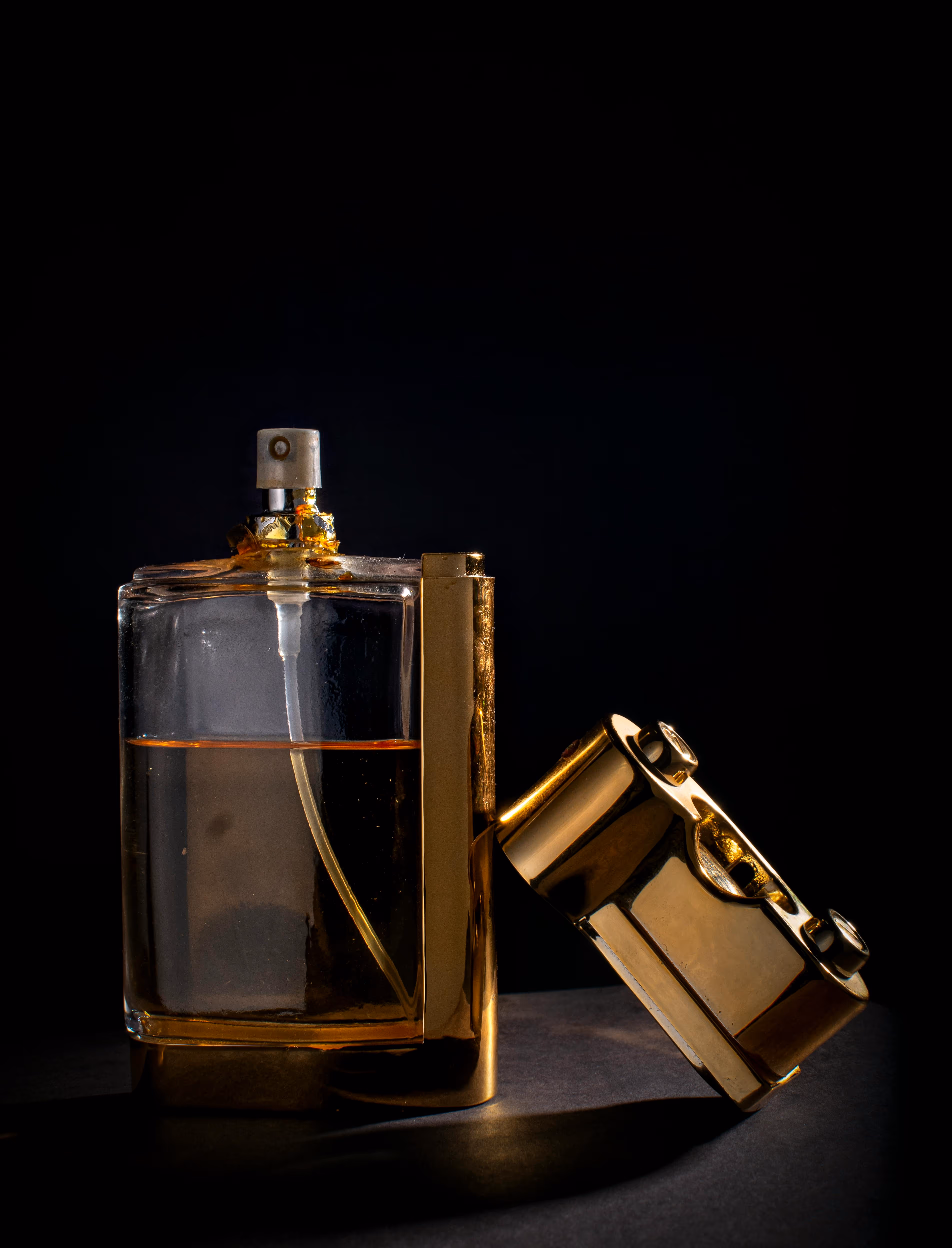 Golden perfume bottle on black background.