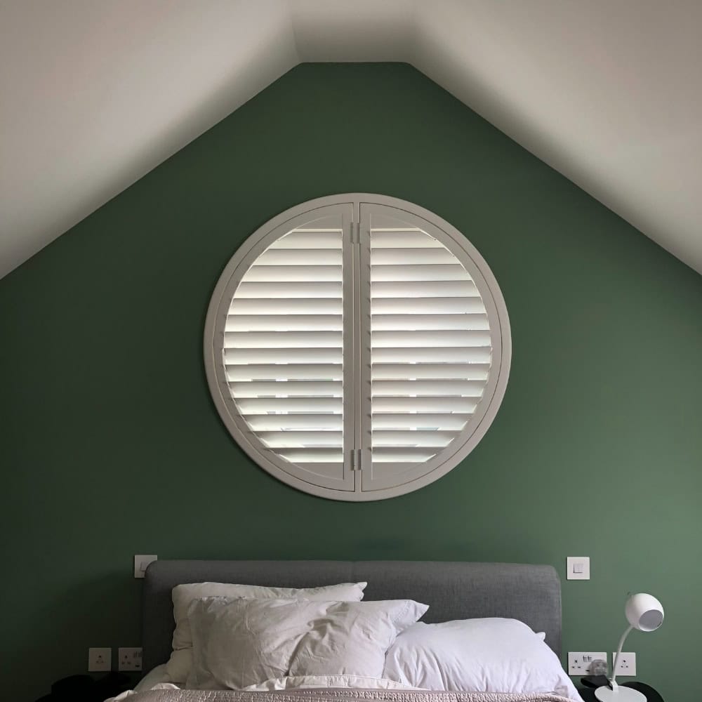 white circular shaped shutter on green wall