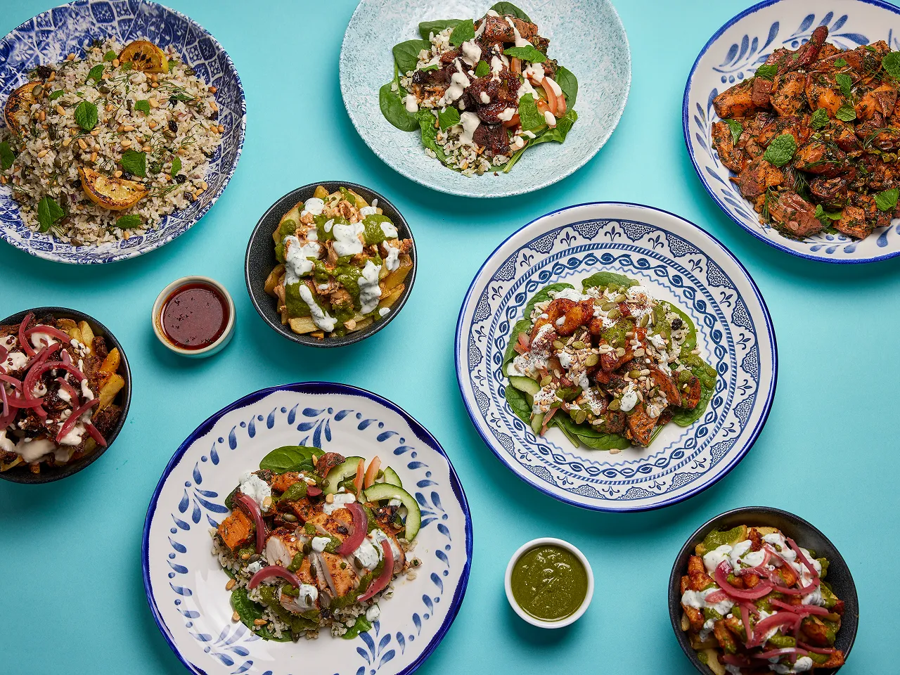 Multiple plates of food on a blue background.