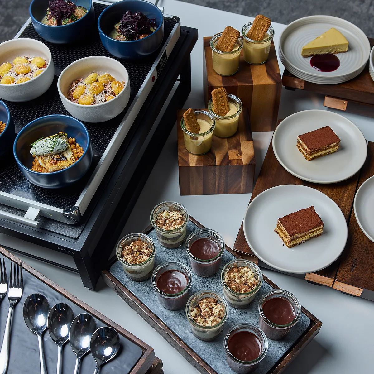 Lots of different delicious desserts on multiple levels and surfaces.